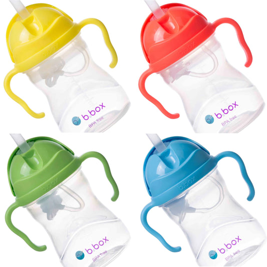 A collection of four bbox sippy cups in different colors: yellow with a yellow lid, red with a red lid, green with a green lid, and blue with a blue lid.